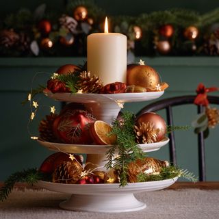 tiered tray on christmas table with pine cones and baubles