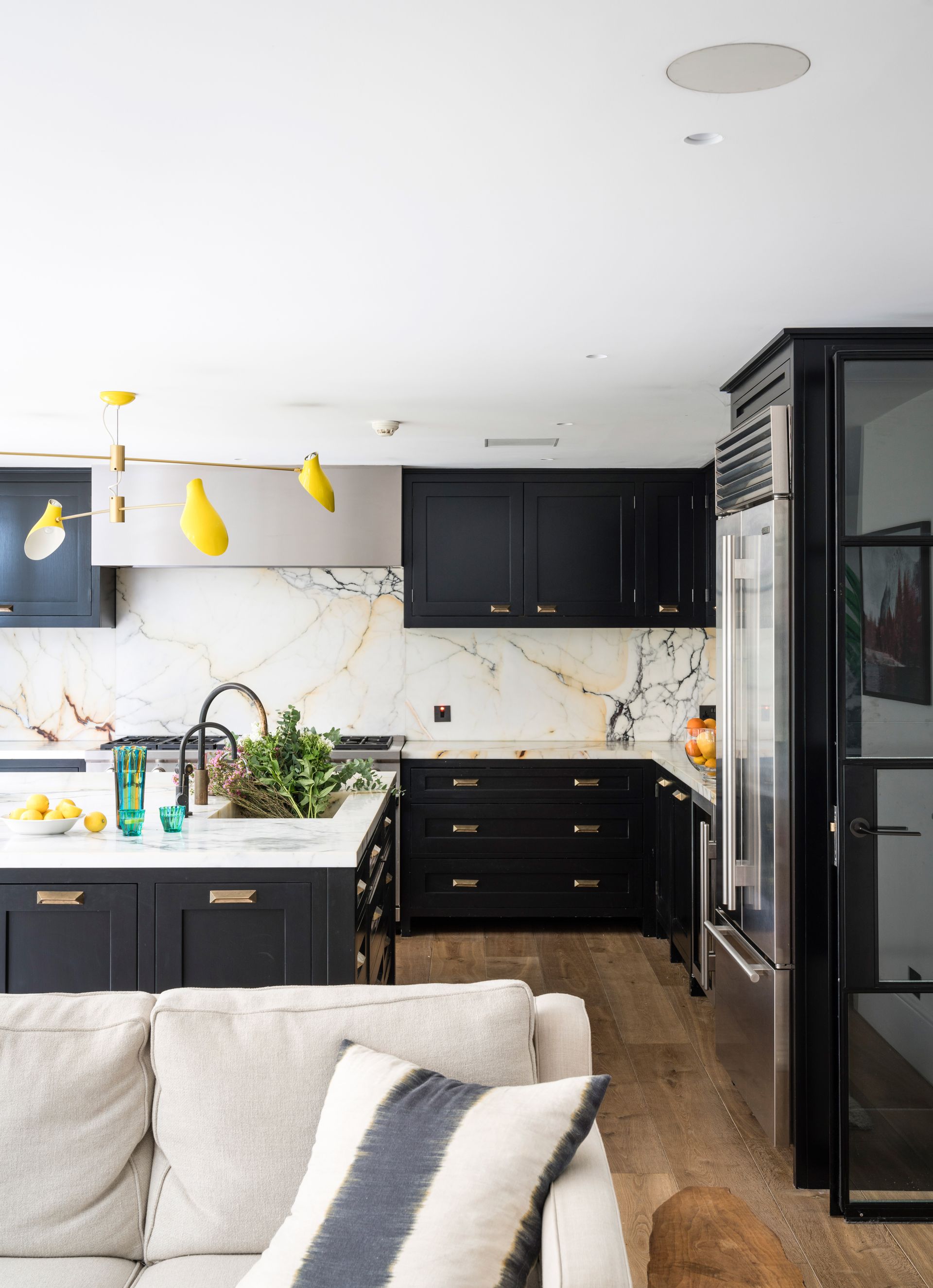 Black open plan kitchen with statement yellow pendant light
