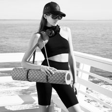 Kaia Gerber wears a celine pilates set with a celine workout mat in front of the malibu beach