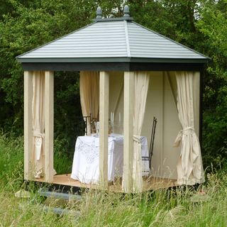summer house with curtains and table and chairs