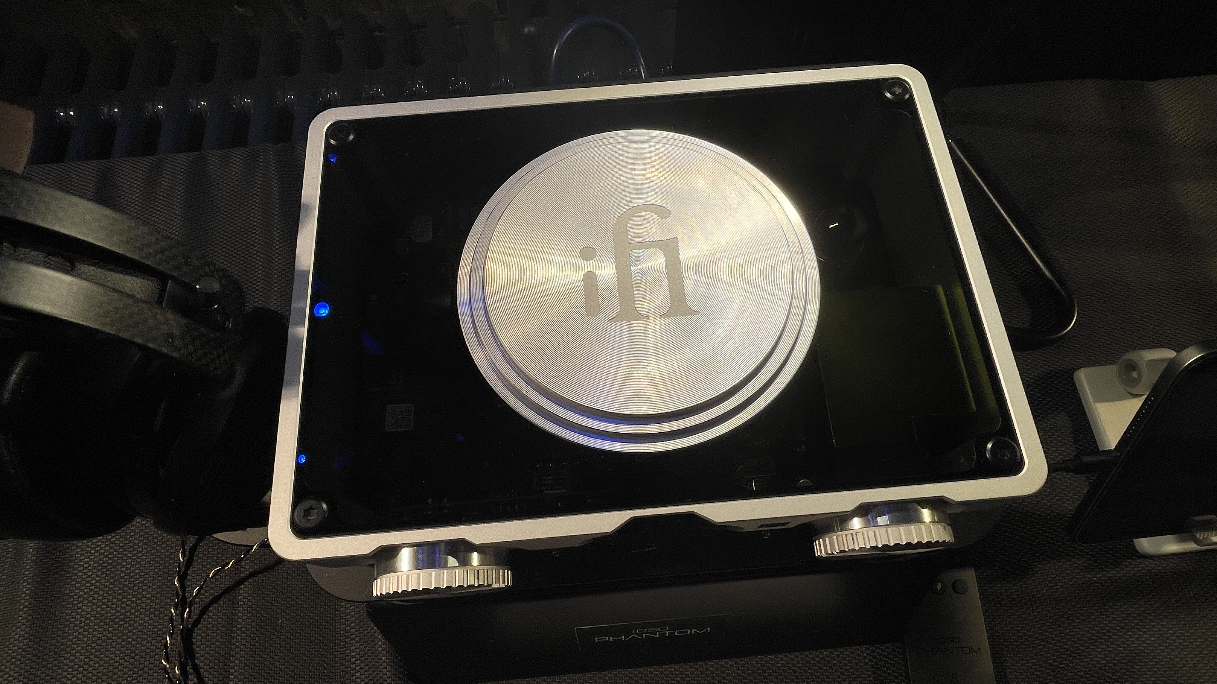 The formidable iFi iDSD Phantom in Tower Bridge, London, used with headphones and illuminating the front panel 