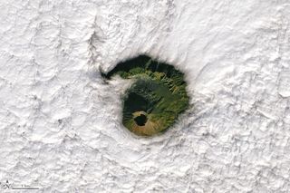 In this image captured Jan. 2 by the Landsat 8 satellite Mount Vesuvius is clearly visible through a circular hole in the clouds.