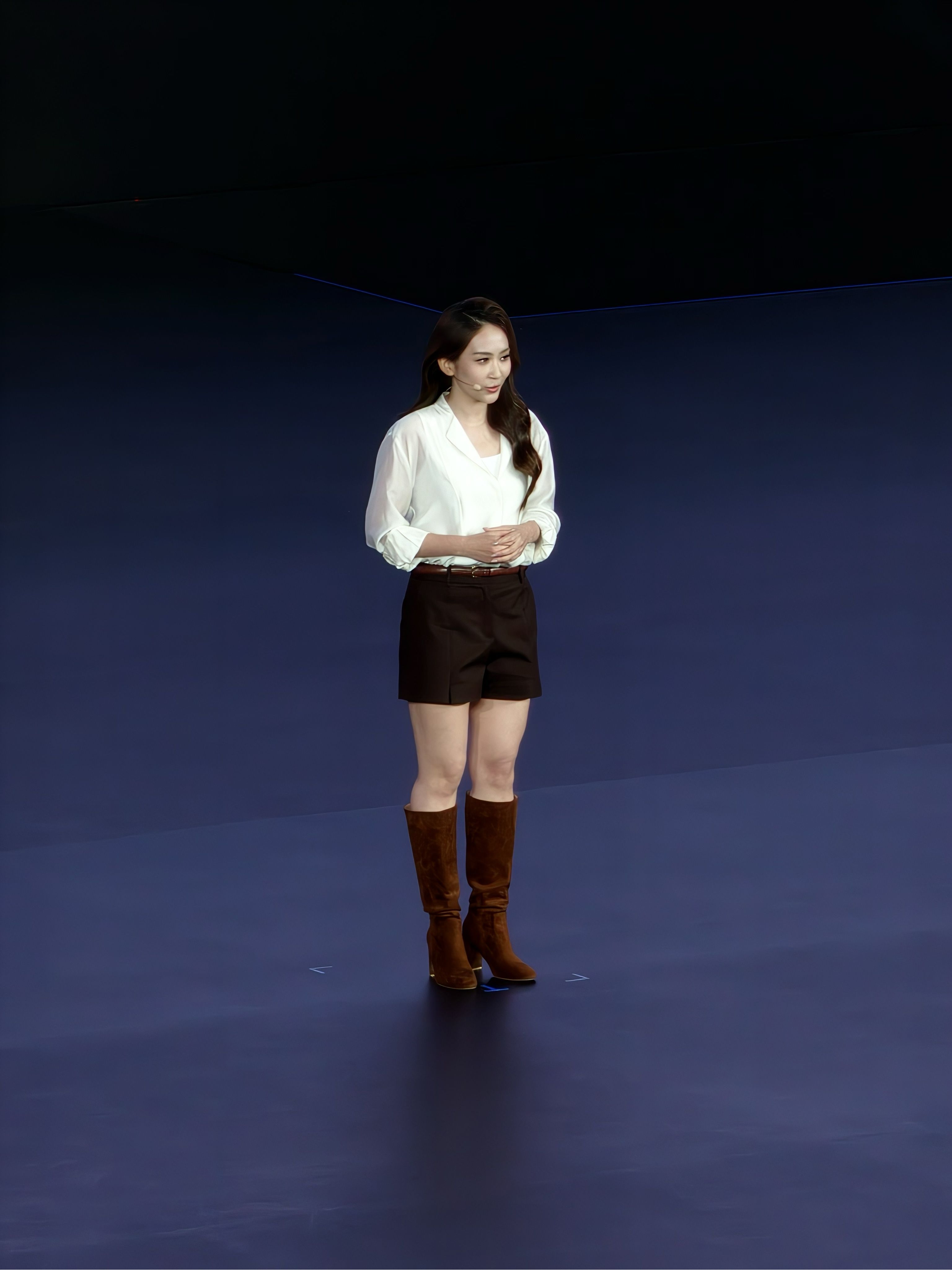 Woman standing on stage presenting
