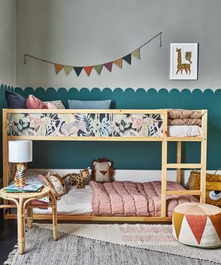 Kids bedroom with bunk bed decorated with wallpaper and scalloped decorated wall behind