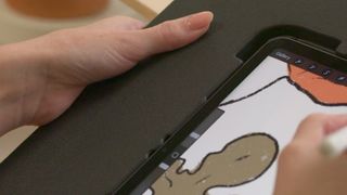 Astropad Darkboard iPad accessory; a woman holds a black iPad drawing frame