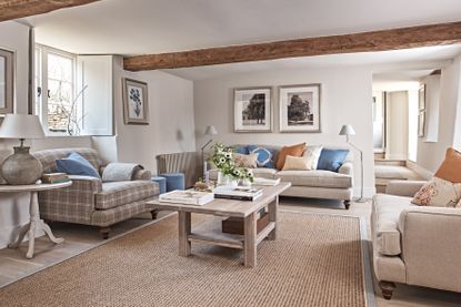 Wicker rug, grey walls and sofa, exposed wooden beam