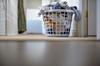Full laundry basket placed on the floor