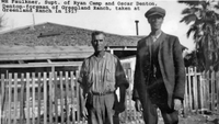 Two men, one of them the foreman of Greenland Ranch in Death Valley in the early 1900s, stand in front of the ranch.