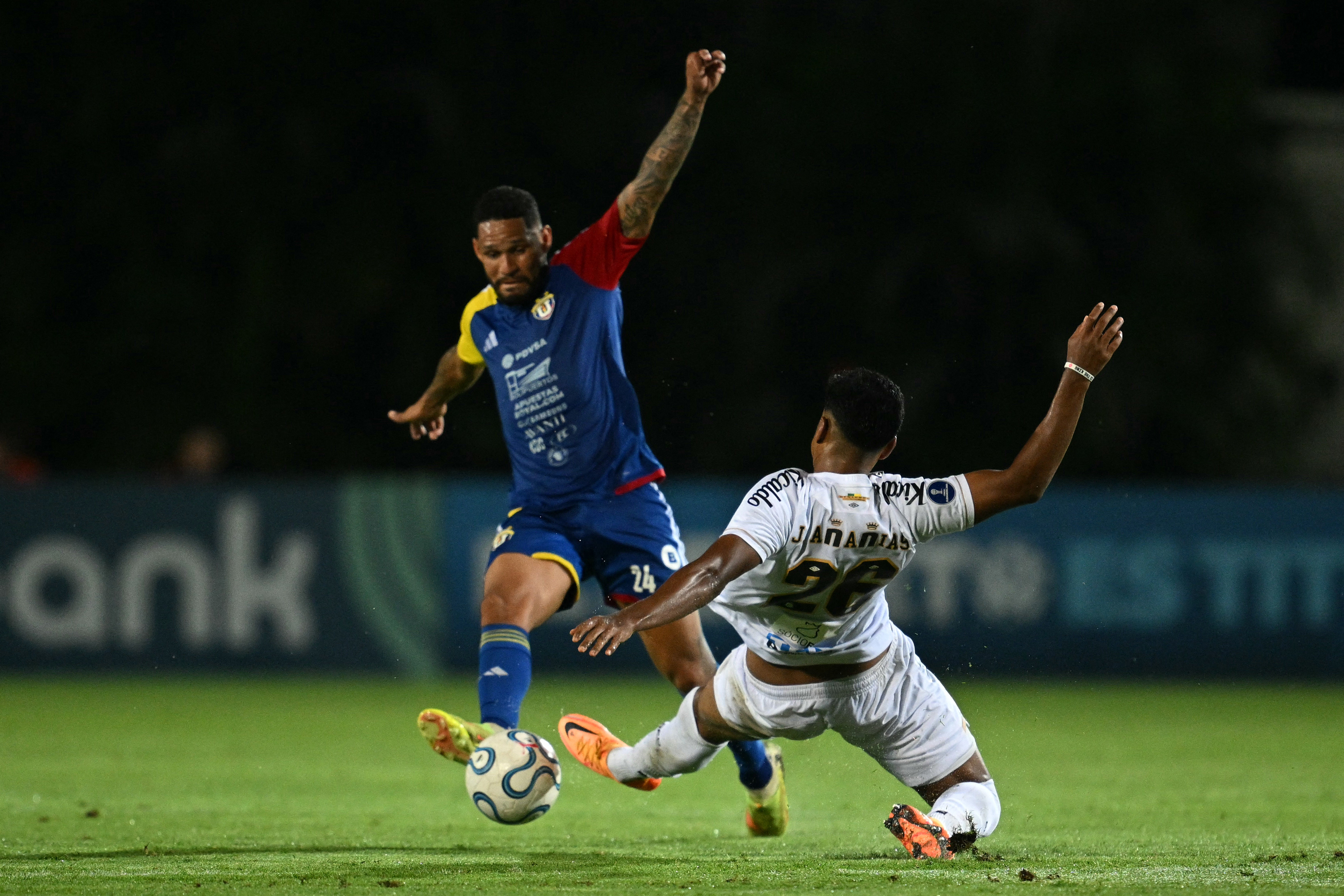 Universidad Central's defender #24 Yohan Cumana (L) and Santos' defender #26 Joao Ananias fight for the ball