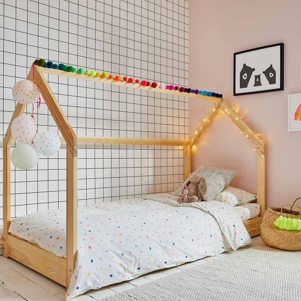 girls bedroom with pom poms and bed