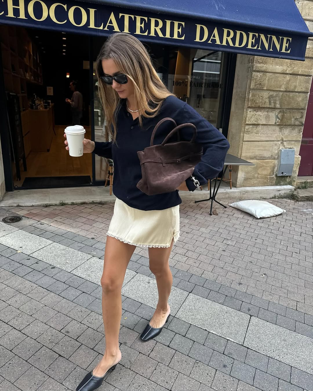 French Fashion Trends 2025: @annelauremais wears a yellow slip skirt with a navy jumper and carries a brown bag