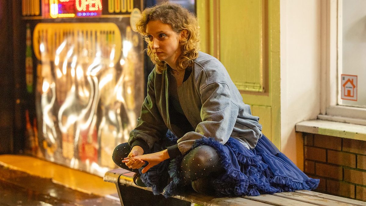 Emily Fairn as Casey, wearing a hoodie and skirt