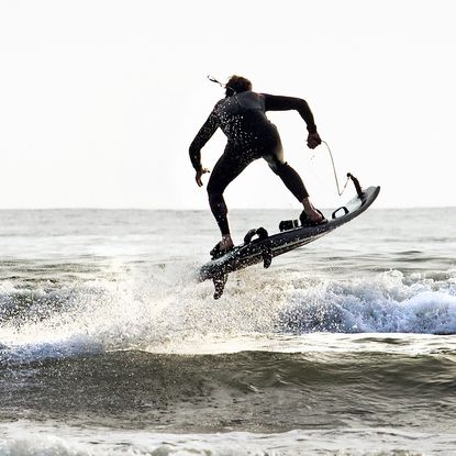 Man in wetsuit skims water on Mako Board