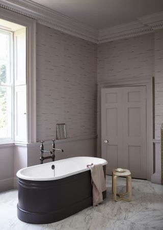 lilac purple bathroom with wallpaper and freestanding bath by Paint & Paper Library