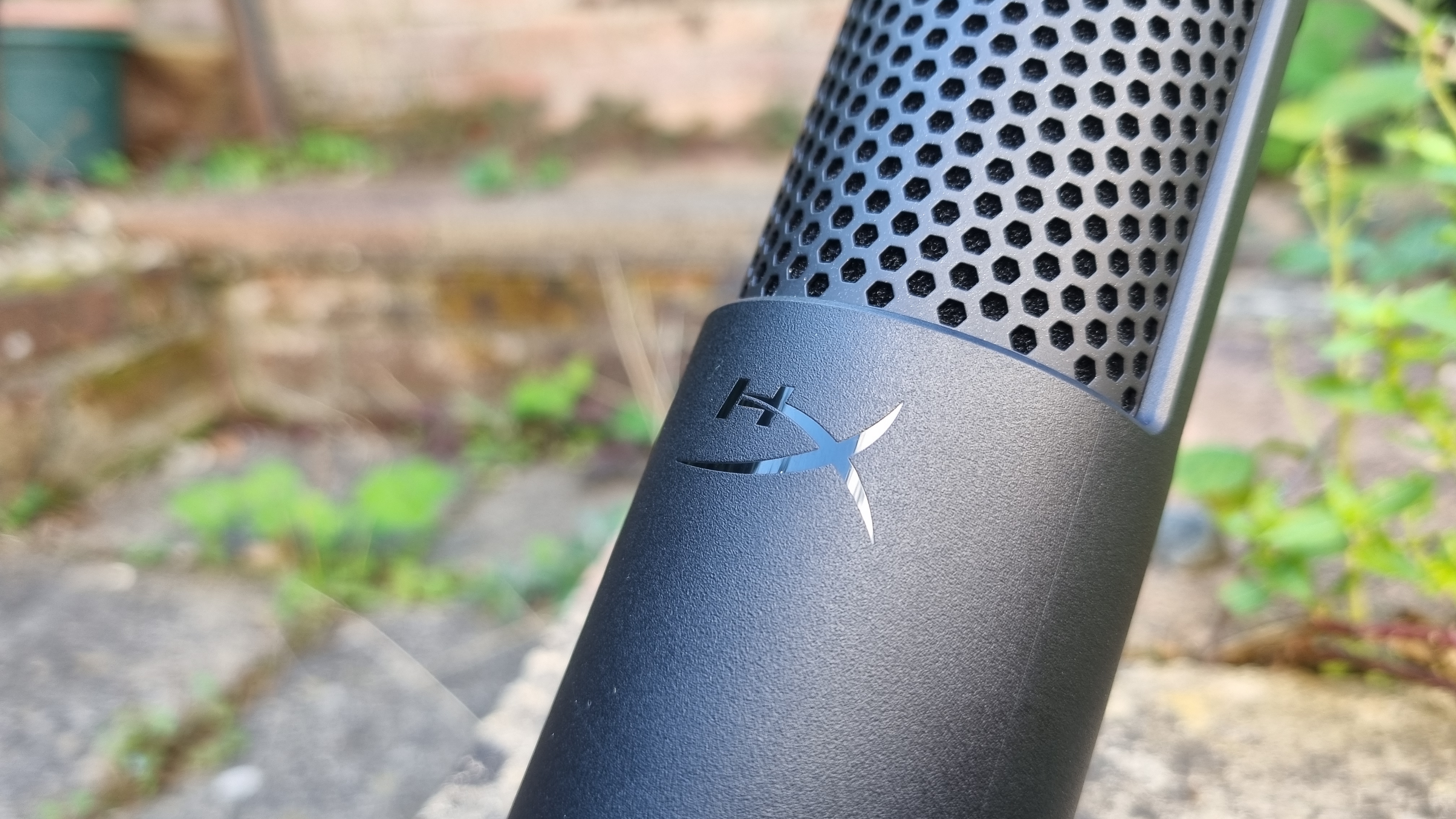 A close up of the HyperX logo on the HyperX SoloCast 2 USB microphone