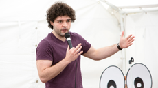 Edd Hedges on stage with a microphone