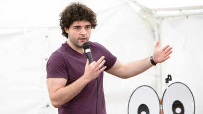 Edd Hedges on stage with a microphone