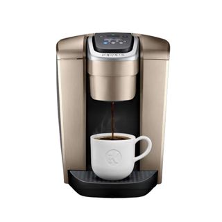 Keurig K-Elite® Single Serve Coffee Maker in gold with a white mug