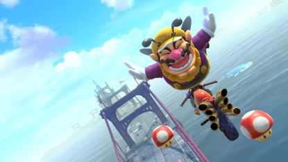 Bee Wario pops a trick off Crown City Bridge in Mario Kart World
