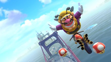 Bee Wario pops a trick off Crown City Bridge in Mario Kart World