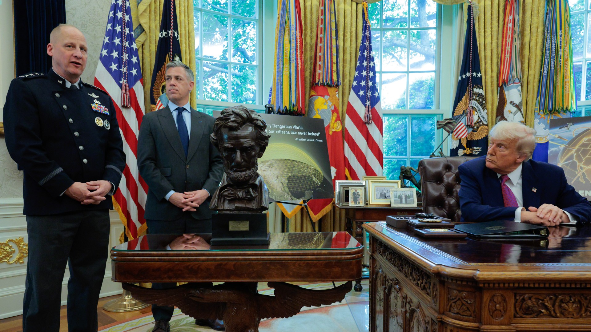 men in suits speak to reporters around a large wooden desk