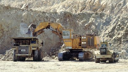 Excavator filling a dump truck at a gold mine 