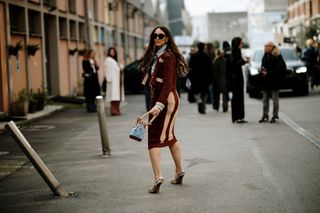 A woman at Milan Fashion Week carrying a Fendi denim bucket bag