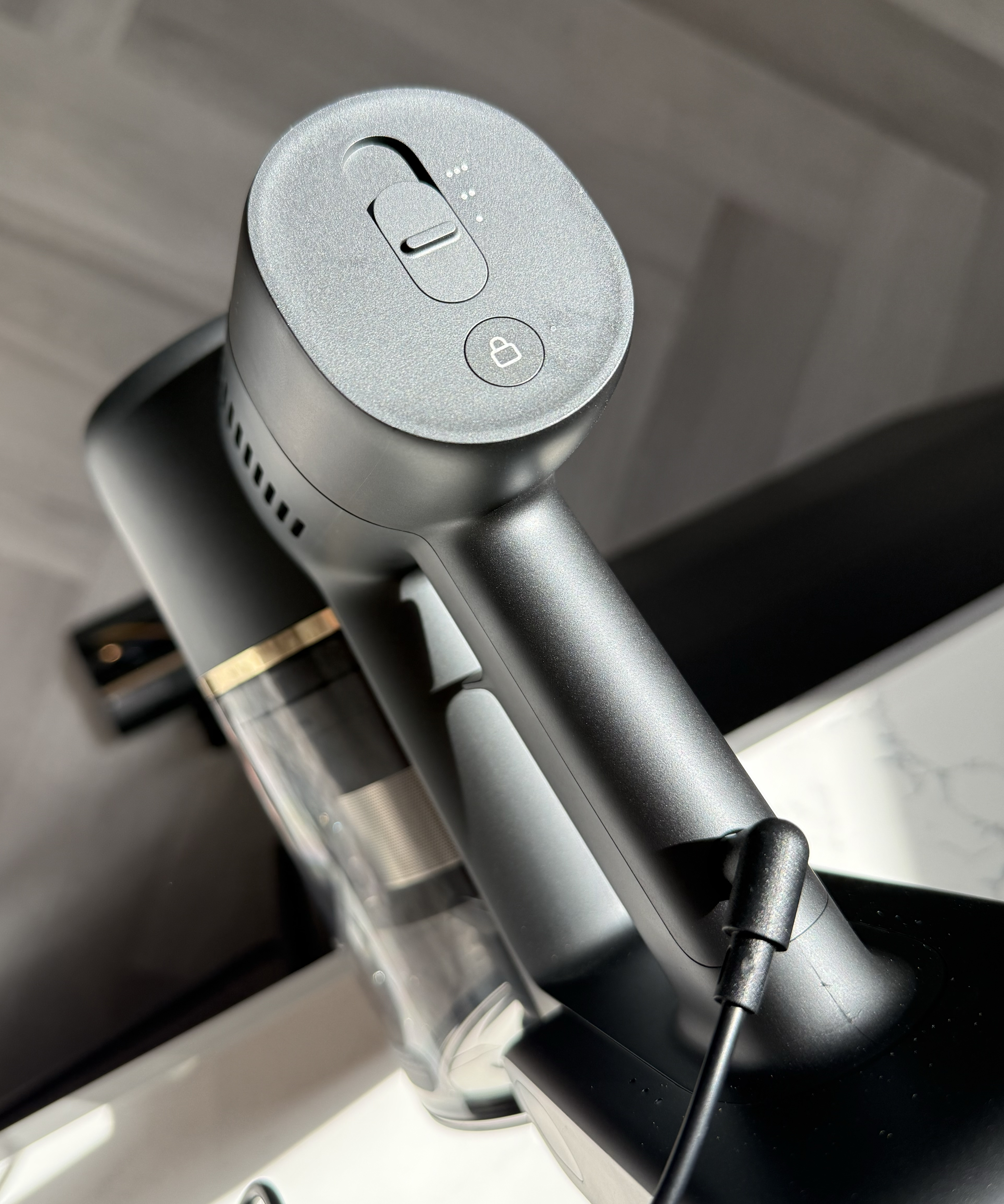 Dreame R10 Pro handheld vacuum body sitting on its charging dock with the cable connected