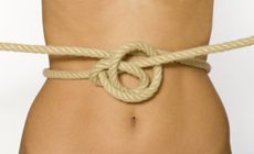A woman's abdomen shown with a knotted rope in front