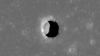 An image of a vast lunar pit on the surface of the moon.