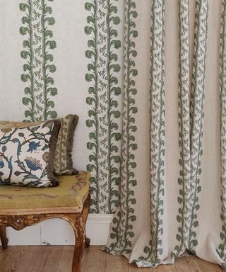 Cream and green patterned curtains, wood floor, wood chair decorated with cushions