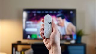 Google TV remote in front of TV