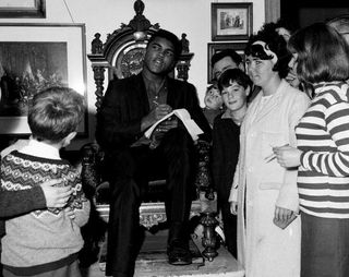 Muhammad Ali 1965 in Burns Cottage watched by crowd