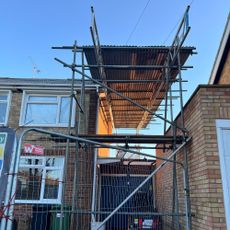 Temporary roof erected with scaffolding above home extension