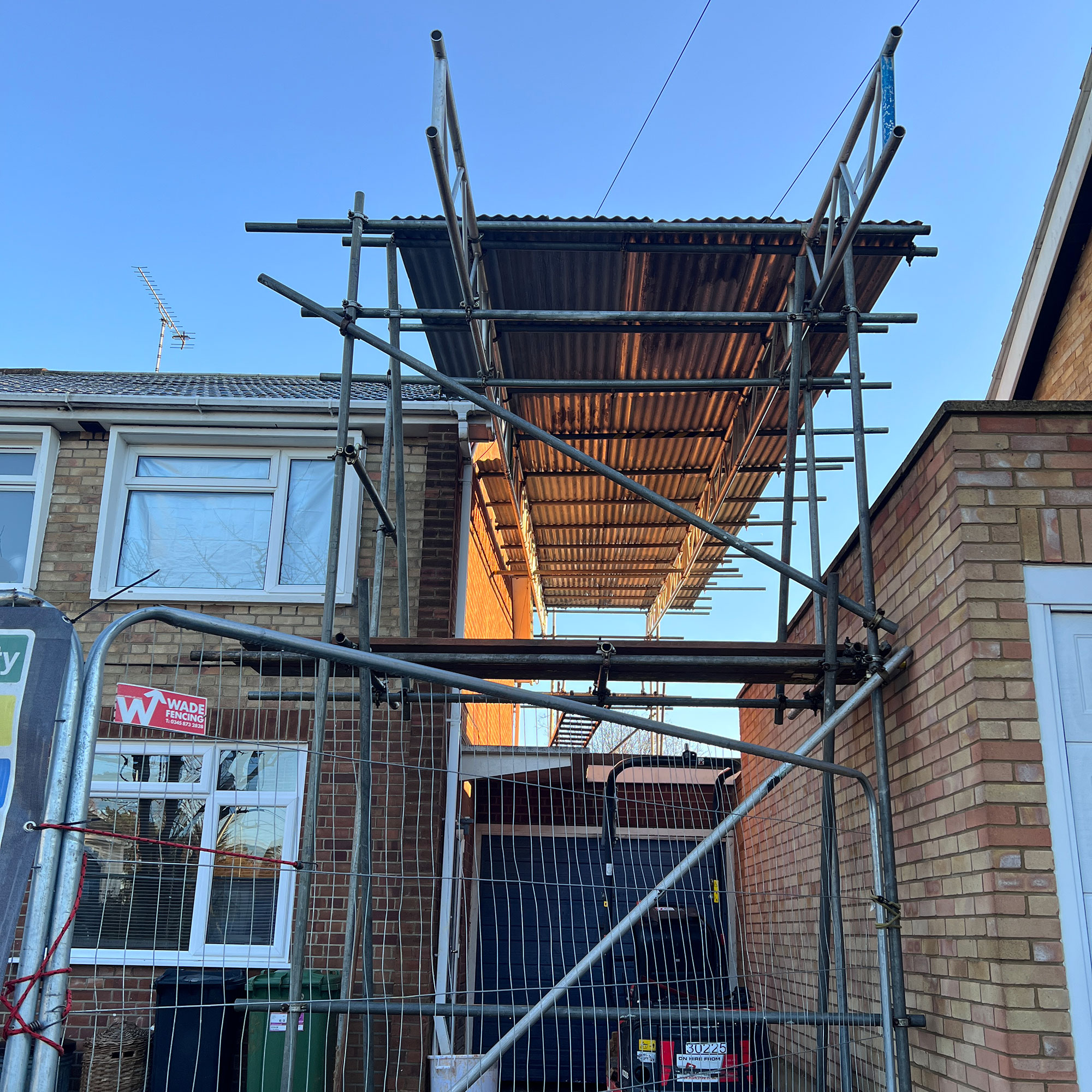 Temporary roof erected with scaffolding above home extension