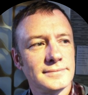 Headshot of dark haired man with close cropped hair