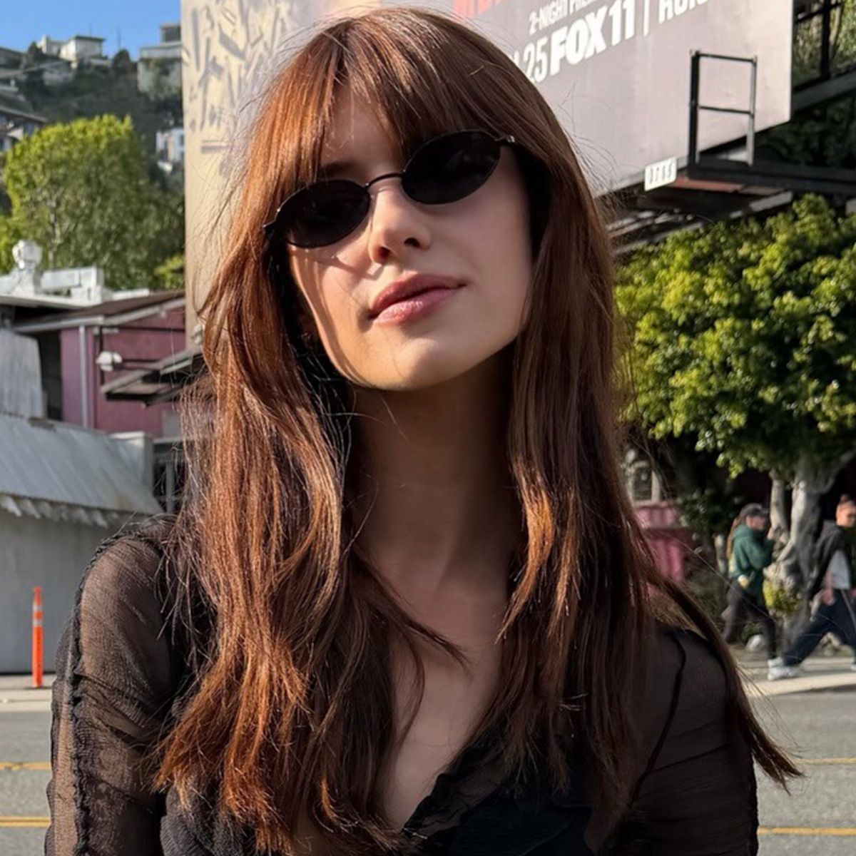 Daisy Edgar-Jones wearing a black going-out top with high-waisted jeans and a black Prada clasp bag on Sunset Boulevard in Los Angeles.