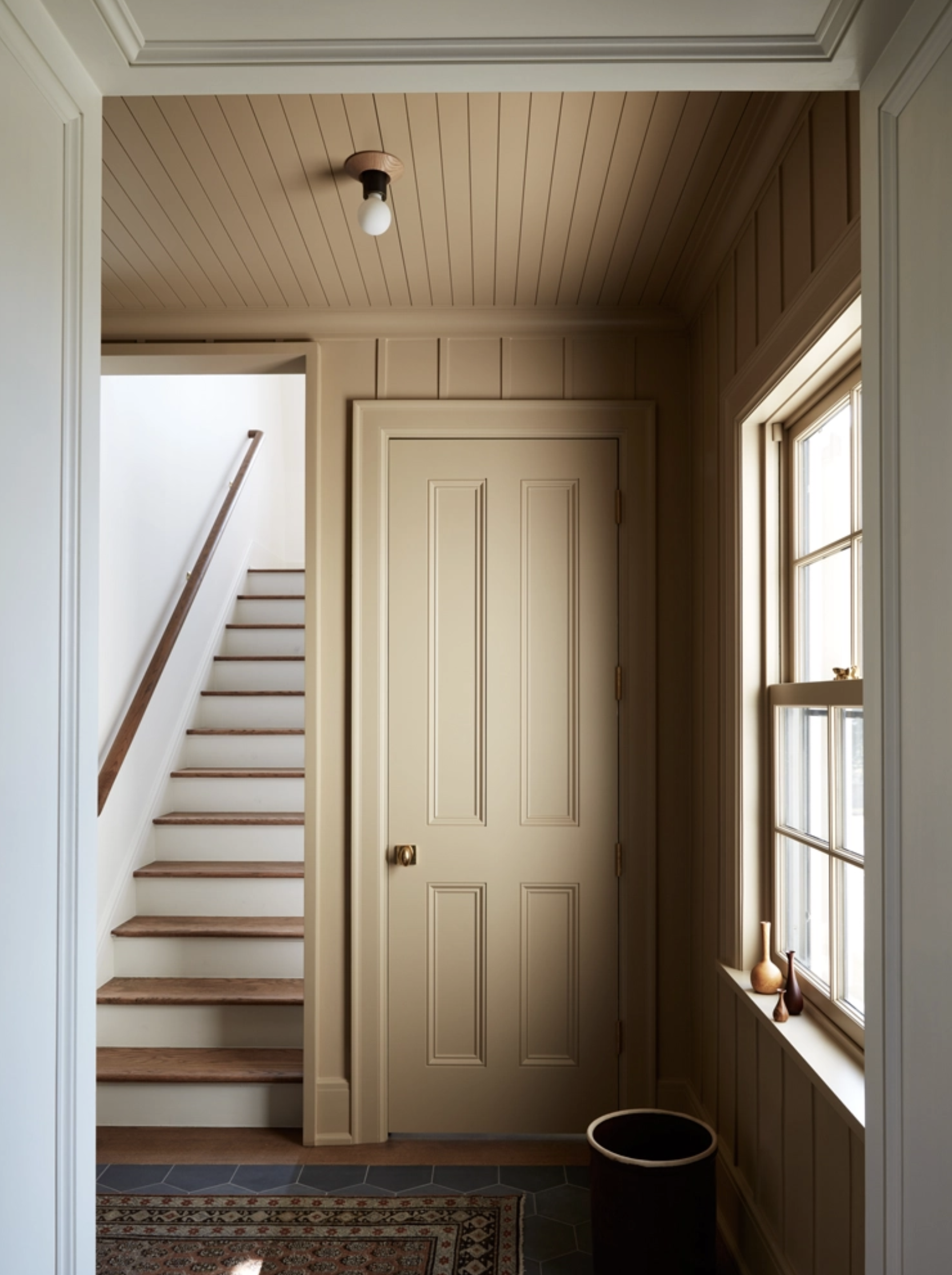 muted, warm beige color drenched entryway with millwork