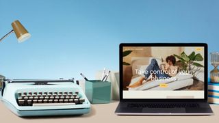 A laptop, showing the Squarespace site on screen, on a desk next to stationery, a typewriter and a desk lamp.
