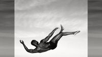 Man falling through air against a cloudy sky