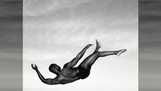 Man falling through air against a cloudy sky