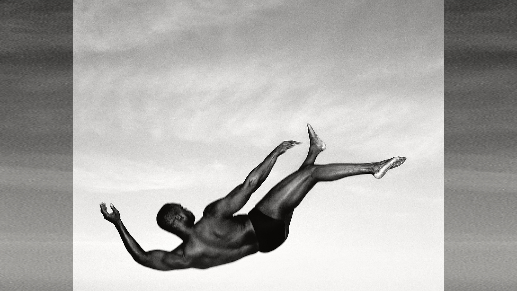 Man falling through air against a cloudy sky