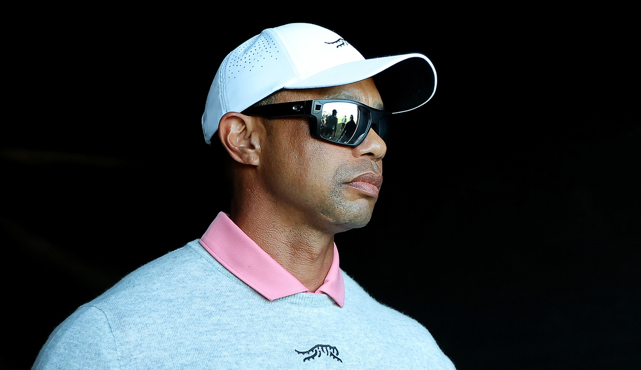 Tiger Woods looks forward wearing sunglasses