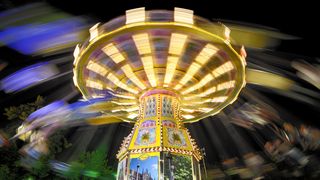 spinning fair ride shown in motion while lit up at night