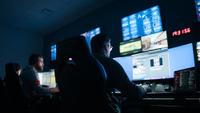 Men working in a dark control room