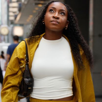 Coco Gauff's track skirt pulled off the mustard yellow color trend for fall with New Balance sneakers