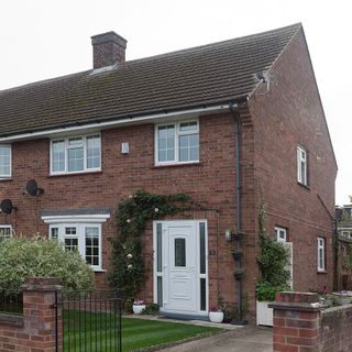 house exterior with brick walls metal fencing and sash windows