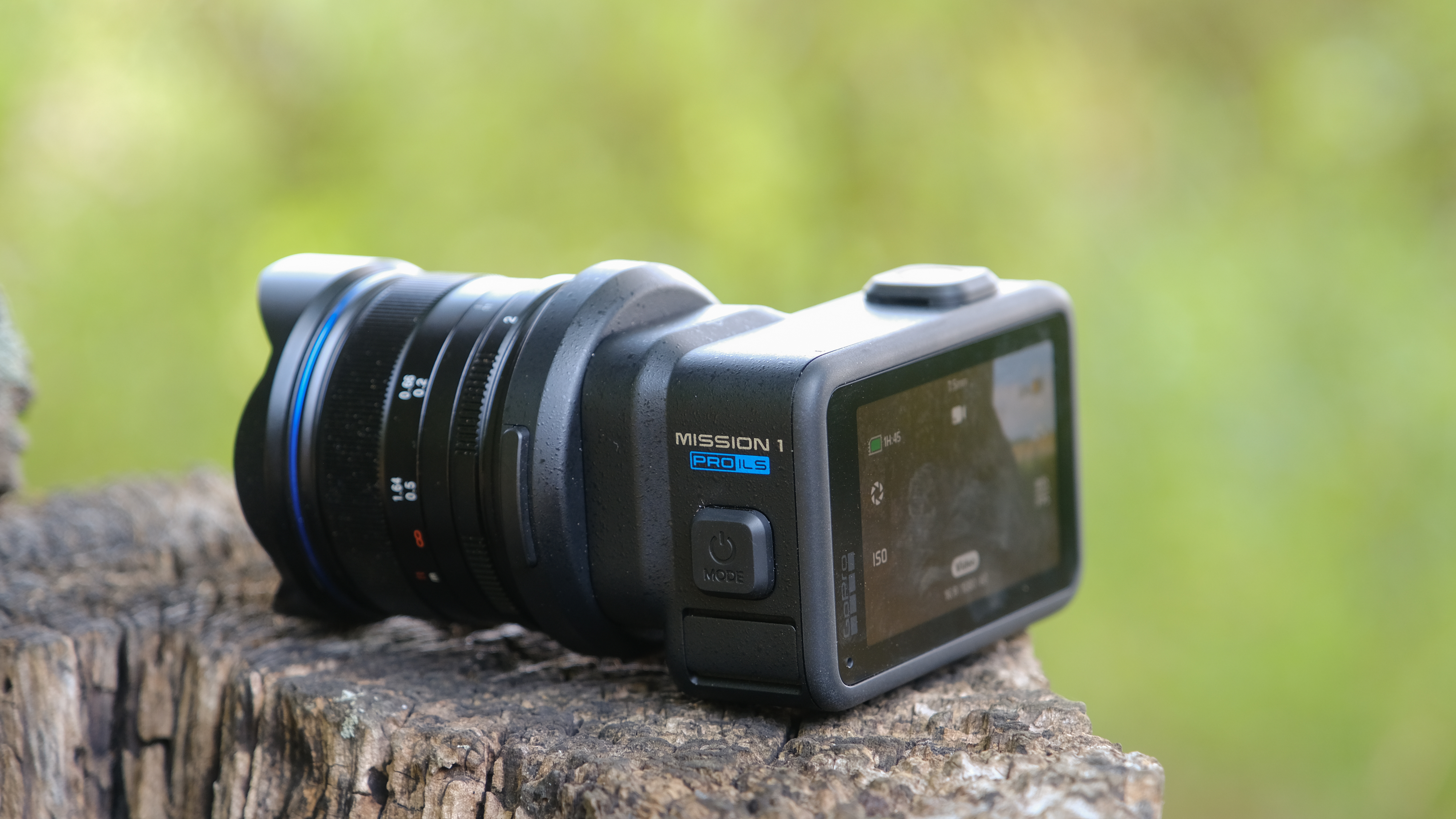 The GoPro Mission 1 ILS mirrorless camera photographed outdoors on a tree stump