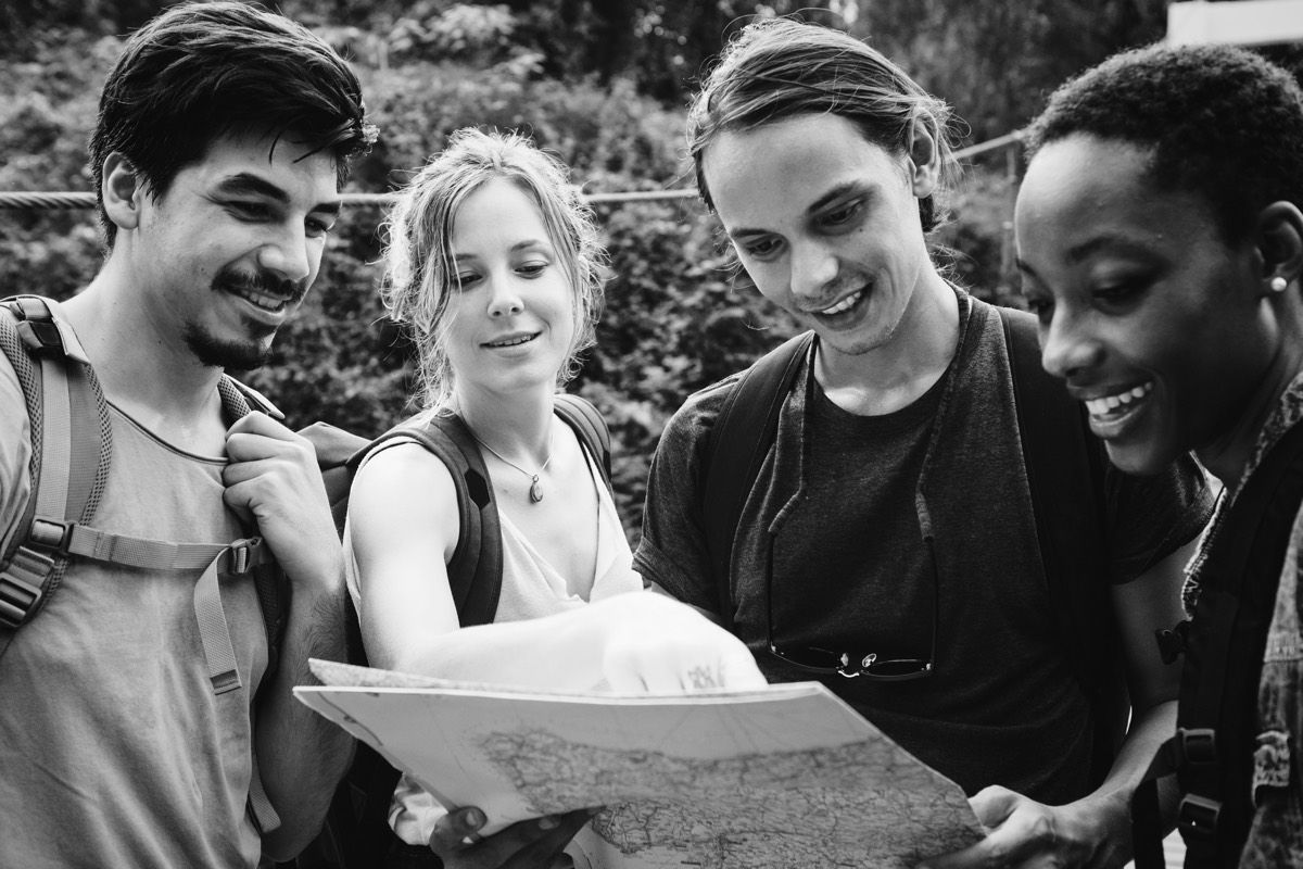 A group of friends looking at a map while hiking.