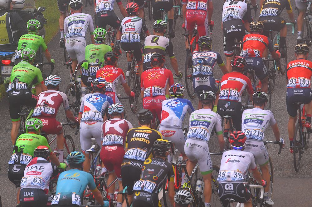 The peloton climbs in the fog during stage 12 at the Tour de France
